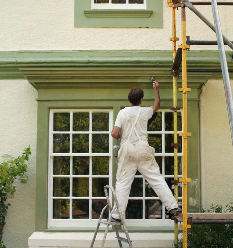 a man painting the house exterior