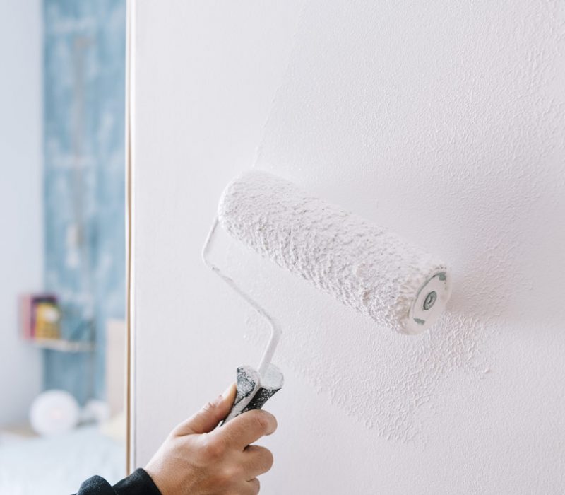 painting the wall using a roller paint brush